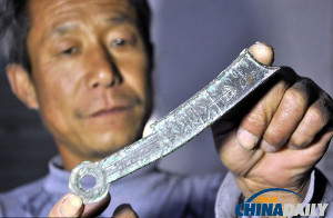 A farmer from Shandong displays the knife money he discovered from the ancient State of Qi